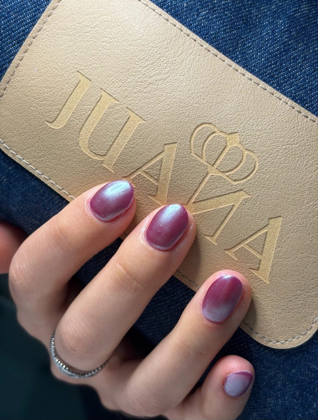 Mesa de manicura de mármol blanco y repisa con esmaltes profesionales en JUANA Beauty Space